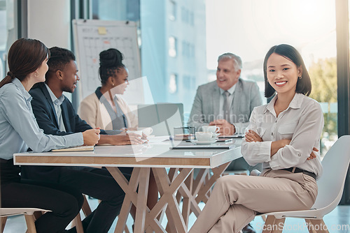 Image of Asian woman, portrait and arms crossed for leadership in meeting, management or planning at the office. Happy female leader or manager with smile sitting at conference table for team project plan