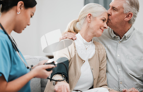 Image of Kiss, nurse or old couple with blood pressure test consulting in hospital to monitor heart healthcare. Doctor, hypertension consultation or medical physician with a happy patient for examination