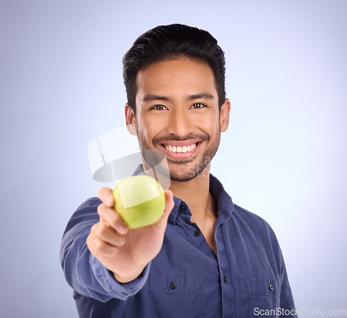 Image of Portrait of happy man with apple isolated on studio background healthy diet, healthcare or nutritionist breakfast. Vegan person or asian model with green fruit or food for dietician care and choice
