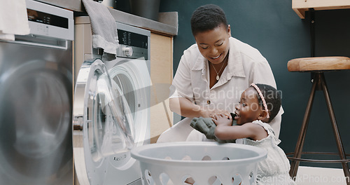 Image of Laundry, mother and child helping with folding of clothes together in a house. Happy, excited and young girl giving help to her mom while cleaning clothing from a washing machine in their home