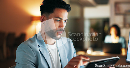 Image of Confident business planning a marketing strategy on a digital tablet while working in a modern office. Young professional using an online app to manage time and balance his tasks, a list for success