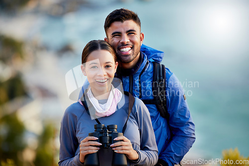 Image of Couple, hiking portrait and backpack together with smile, binoculars and adventure for fitness on mountain. Gen z man, woman and outdoor for travel, holiday and training with love, bonding and care