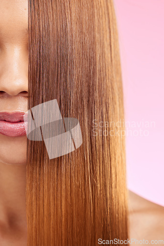 Image of Beauty, hair and half face of black woman isolated in studio with pink background for salon advertising. Haircare, straightener and Brazilian hairstyle on model for luxury growth product promotion.