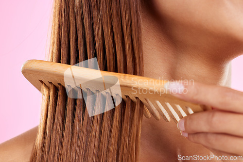 Image of Beauty, comb and bamboo with hair of woman for health, salon and satisfaction in studio. Wellness, keratin and natural with girl model and self care for cosmetics, brush and shine on pink background