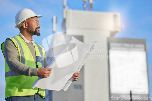 Image of Engineering, blueprint and black man planning at construction site with paperwork. Handyman, outdoor and African male contractor working with architecture plans for building, repairs or maintenance.