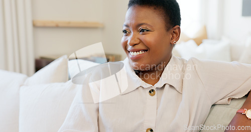 Image of Happy, smile and black woman relaxing on a sofa while watching tv in the living room of her modern house. Happiness, laughing and African lady streaming a movie while sitting on a couch in her lounge