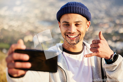 Image of Fitness, hiking and man taking a selfie on the mountain after walking for a exercise in nature. Sports, health and young male hiker taking a picture while trekking outdoor for a cardio workout.