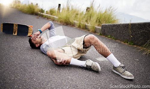 Image of Accident, fall and knee injury with a skater man on the ground, lying down in pain after falling down. Sports, training and anatomy with a young male suffering a skateboard emergency outdoor