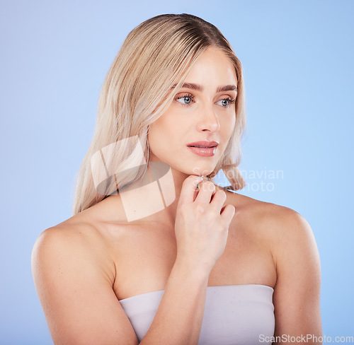 Image of Hair care, beauty face and thinking woman in studio isolated on a blue background. Makeup cosmetics, skincare and young female model with salon treatment for hairstyle, blonde balayage and growth.