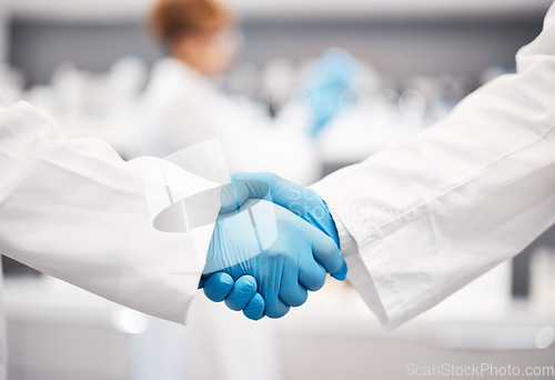 Image of Doctor, shaking hands and gloves for safety in healthcare, partnership or trust for collaboration, unity or support at lab. Team of medical experts handshake in teamwork for agreement or success