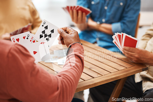 Image of Senior friends, hands or playing card games on wooden table in fun activity, social bonding or gathering. Group of elderly men having fun with cards for poker game enjoying play time together at home