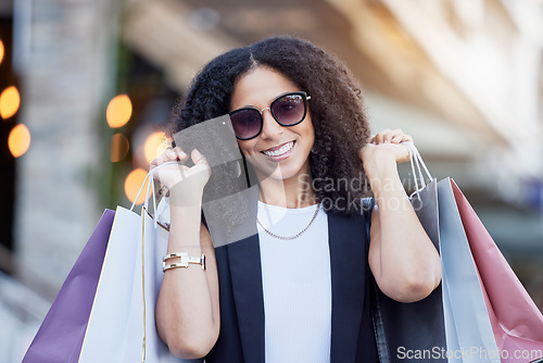 Image of Portrait, shopping and black woman with bags at a mall, happy and excited for sale. Face, fashion and girl with relax with luxury, purchase while walking outdoors, satisfied and cheerful on weekend