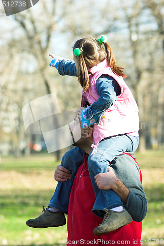 Image of child on father shoulder in the park