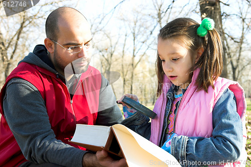 Image of child and father reading the book