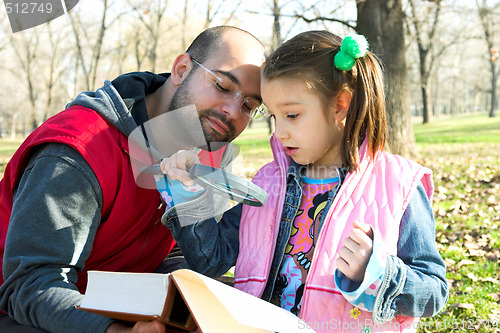 Image of child and father reading the book