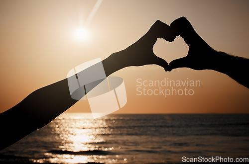 Image of Beach silhouette, sunset and heart hands sign for travel freedom, outdoor peace or nature beauty. Wellness, sky lens flare and emoji gesture for ocean love, sun light or sea water on summer holiday