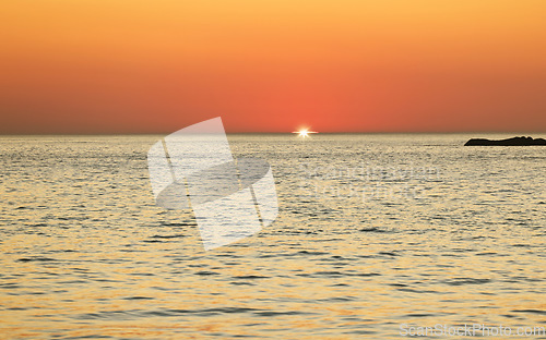 Image of Sunset, ocean and horizon with a view over the sea during summer under an orange sky for mockup. Nature, water and earth with waves on a seascape for zen, peace or inspiration on a sunrise backdrop