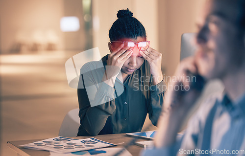 Image of Business woman, headache and computer in stress, burnout or suffering pain at night by office desk. Female employee rubbing head or touching painful area by desktop PC feeling overworked at workplace