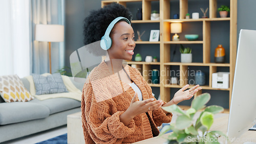 Image of Call center agent talking and helping customers while wearing a headset and working on a desktop computer at home. Happy and cheerful black woman working in sales and networking with clients online