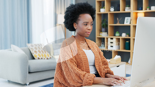 Image of Young woman working remotely on a computer from home. Dedicated student browsing the internet while doing research and planning for an online course. Confident freelance entrepreneur typing a blog