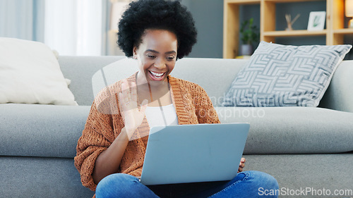 Image of Happy African American woman using laptop and waving on a video call in a living room. Young black female having a casual chat with friends at home. Lady excited to talk to her family during lockdown