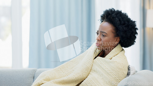 Image of Woman sick with the flu on a couch at home, sneezing and blowing her nose. Young female suffering from sinus, allergies or covid19 while isolating. Lady taking off from work to recover from a cold