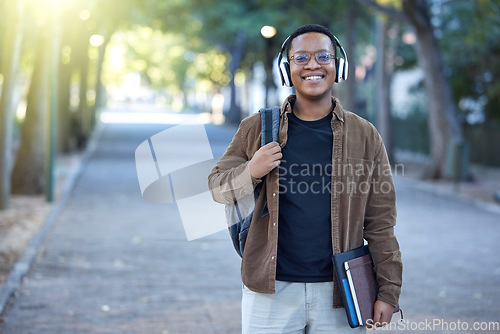 Image of Music, education and portrait of a black man at a park for a walk, learning and studying in nature. Happy, university and African student with headphones for audio while ready to start college