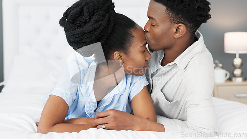 Image of Love, support and trust between black couple sharing a special bond and communication while spending time in the bedroom. Commitment, marriage and understanding with man kissing head of woman