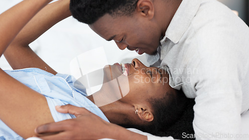 Image of Black man and black woman couple kiss. Young, in love and African American people in relationship saying I love you. Kissing, romantic and smiling face to face in bed together at home, intimacy