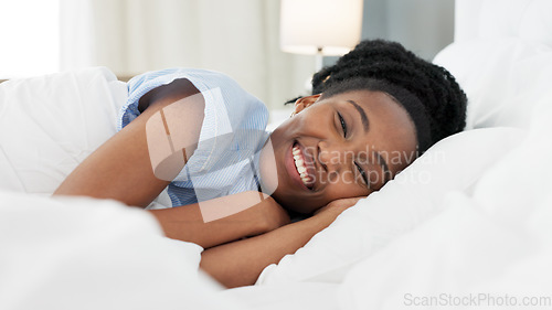 Image of Sleep, bed and relax with a black woman sleeping in the bedroom of her home and dreaming. Resting, relaxing and peace with a young female lying on a pillow and under a duvet in a house in the morning