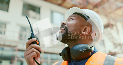 Image of Construction site, black man and building manager with walkie talkie for logistics, development and update. Project management, communication and construction employee speaking with portable radio.