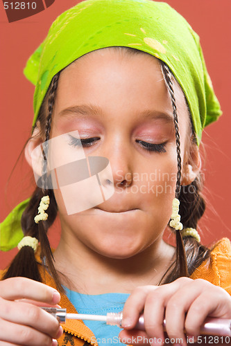 Image of child applying make-up