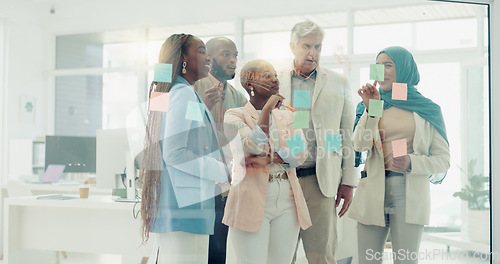 Image of Meeting, planning and sticky notes on glass in the office with a diversity business team planning strategy. Teamwork, collaboration and coaching with a black woman leader teaching her staff at work