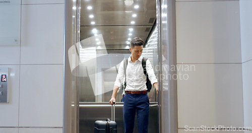 Image of Elevator, travel and watch with a business asian man in an airport, checking the time of his flight for departure. Door, floor and late with a male employee holding suitcase luggage while traveling