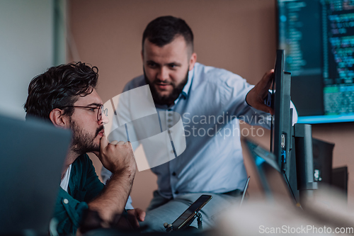 Image of Programmers engrossed in deep collaboration, diligently working together to solve complex problems and develop innovative mobile applications with seamless functionality.