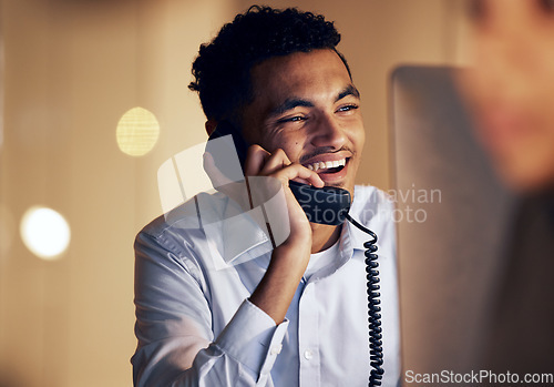 Image of Telephone, night and businessman on a phone call in the office talking while working on a computer. Discussion, communication and professional male employee speaking on a landline in the workplace.