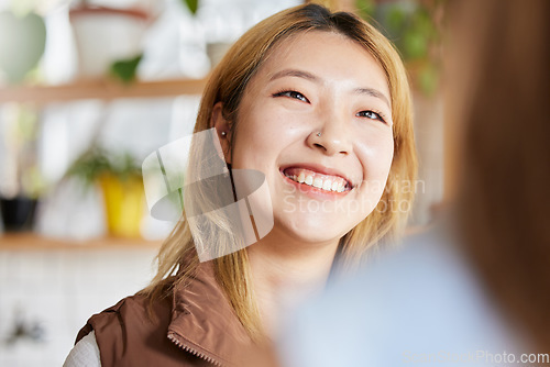 Image of Face, happy or smile and an asian woman in a coffee shop, enjoying spending time with a friend. Cafe, brunch and lifestyle with an attractive young girl sitting in a restaurant for a chat or catch up