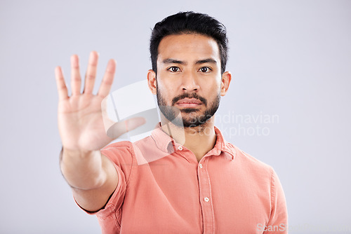 Image of Stop, serious and portrait of an Asian man with a hand isolated on a grey studio background. Negative, no and Japanese guy with a gesture for rejection, deny and forbidden warning on a backdrop