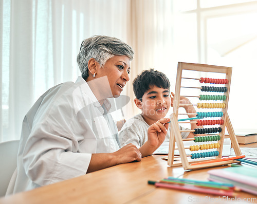 Image of Education, autism and abacus with a grandmother teaching maths to her grandchild in the home for child development. Family, homework or study and a boy learning with a senior woman tutor in a house