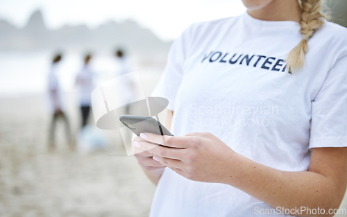 Image of Phone, hands and volunteer woman at beach for cleaning, social media and web browsing. Earth day, environmental sustainability and female with 5g mobile smartphone at seashore for community service.