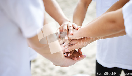 Image of Hands together, teamwork and collaboration of people for sustainability or eco friendly at beach. Earth day, volunteer and group of men and women huddle for community service, support or charity.
