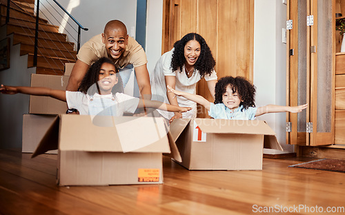 Image of Children in boxes while moving into a new home with their parents playing in a silly, goofy and fun mood. Happy, smile and family being playful together in their modern house, apartment or property.