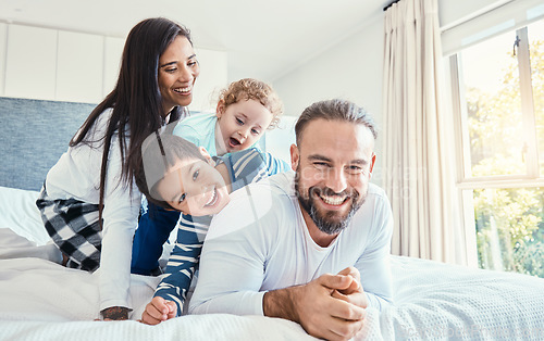 Image of Family, portrait and laughing on bed in home, having fun and bonding together. Comic, love and care of happy father, mother and kids or boys playing, smile and enjoying quality time in house bedroom.