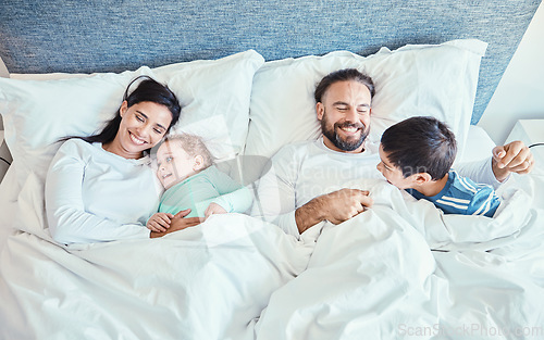 Image of Morning, relax and happy with family in bedroom for wakeup, affectionate and bonding from top view. Smile, care and sleeping with parents and children in bed at home for playful, happiness or support