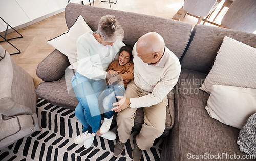 Image of Relax, playful and child with grandparents on sofa of living room for bonding, affectionate and embrace. Support, care and break with senior people and boy at home for happiness, generations and hug