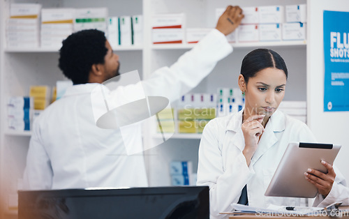 Image of Thinking pharmacist, woman and tablet in medicine check, stock take or medical research in drugs store. Serious, ideas and pharmacy worker on technology pills, checklist or ecommerce healthcare order