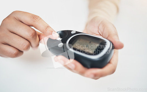 Image of Diabetes, blood test and medical with finger of woman for insulin level, monitoring and glucose check. Medicine, healthcare and digital with hands of patient and glucometer machine for sugar balance