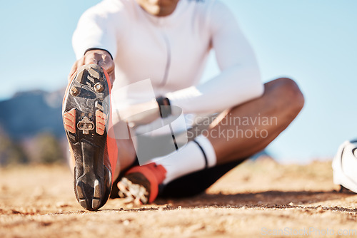 Image of Fitness, stretching and sports with shoes of man in nature for travel, cycling and cardio training. Practice, relax and start with athlete and warm up on trail for exercise, workout and commitment