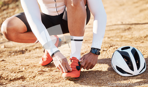 Image of Closeup, tie shoelace and man with fitness, outdoor and helmet for safety, wellness and hobby for exercise. Zoom, shoes and male athlete with protection, sand and in nature for training and workout