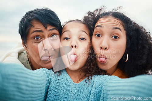 Image of Funny, tongue out and portrait of a family selfie, silly and goofy at the beach in Bali. Comic, crazy and girl taking a photo with a mother and grandmother for a playful memory on holiday at the sea
